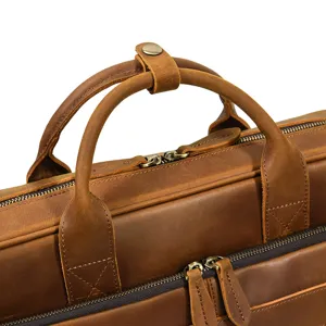 Close-up detail shot of brown crazy horse leather briefcase handle and metal zippers.