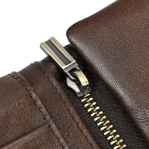 Close-up detail of retro brown leather wallet zipper, premium metal hardware and fine stitching.