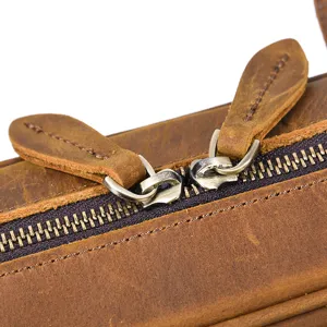 Close-up detail of premium crazy horse leather briefcase zipper and pull tab, durable hardware.