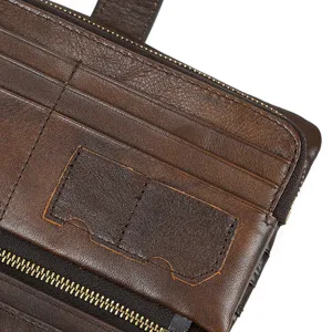Vintage distressed brown leather long wallet interior detail with card slots and zipper.