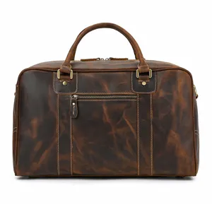 Detalle de bolsa de viaje de cuero marrón, bolso vintage de piel con cremallera metálica.