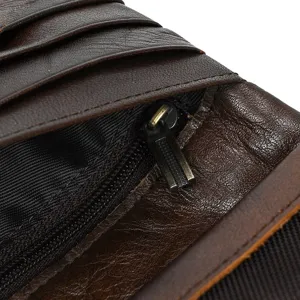 Close-up detail of dark brown leather long wallet interior with card slots and metal zipper.
