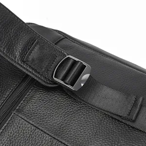 Close-up detail shot of black leather backpack adjustable strap, buckle and durable nylon webbing.