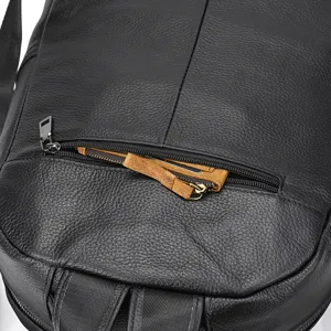Leather backpack detail showing black cowhide texture and zipper pocket. Perfect men's bag.