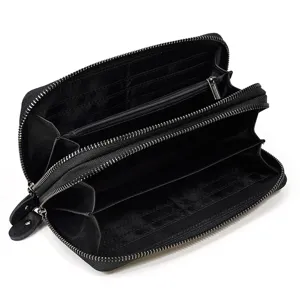 Primer plano detallado de la cartera larga de cuero negro con cremalleras dobles y ranuras.