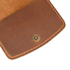 Close-up view of vintage brown crazy horse leather wallet flap detail with metal snap button.