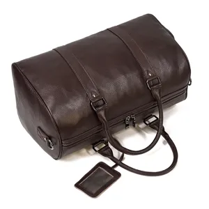 Detail of brown genuine leather travel duffel bag showcasing fine texture and durable handles.