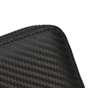 Vista detallada del borde de una cartera negra con textura tejida, cremallera y costuras.