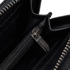 Vista detallada del interior de la cartera de cuero negro con cremallera y compartimentos.