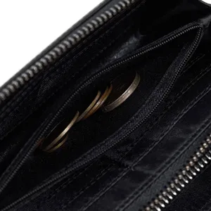 Detalle interior del monedero para hombre con múltiples compartimentos con cremallera y monedas.