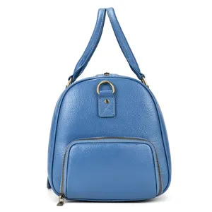 Blue leather travel bag detail view, premium cowhide texture duffel with front zipper pocket.