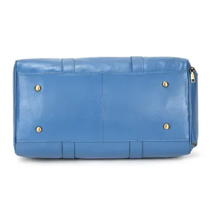 Bottom detail view of blue leather travel duffel bag featuring metal feet and side zipper.