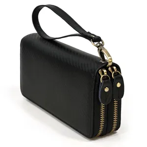 Detalle de cartera hombre negra doble cremallera, bolso de mano con muñequera.