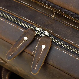 Primo piano dettagliato dello zaino in pelle vintage con robuste cerniere e cuciture.