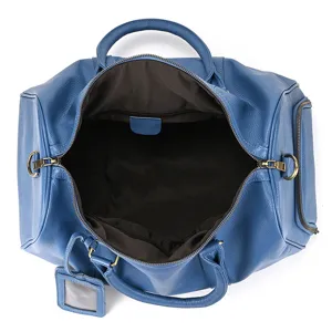 Blue leather travel duffel bag interior detail, spacious main compartment with zipper closure.