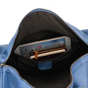 Interior detail view of blue leather travel duffel bag showcasing large capacity and secure storage.