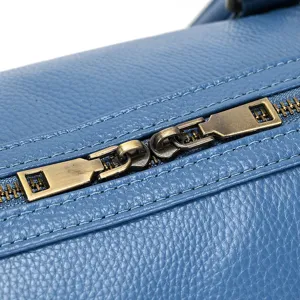 Leather travel bag zipper detail, blue cowhide close up, vintage metal hardware texture