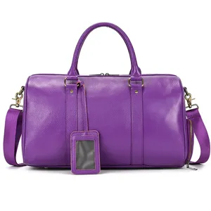 Purple leather duffel bag close-up showing fine texture and durable metal hardware details.
