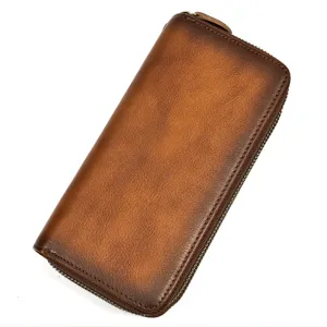 Detalle en primer plano de la cartera de cuero marrón vintage con cierre de cremallera.