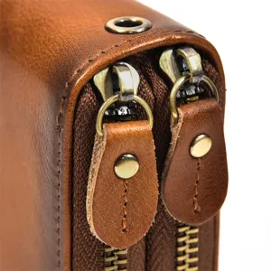 Primer plano de cartera de hombre de cuero genuino vintage con doble cremallera y herrajes.