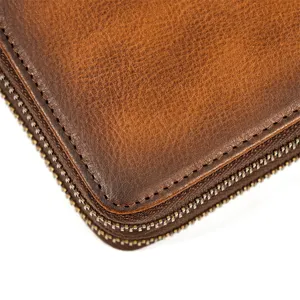 Primer plano detallado de cartera de hombre de cuero genuino marrón vintage con costuras ordenadas.