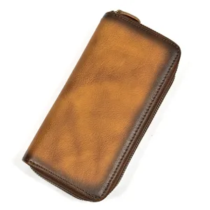 Vista detallada de la cartera larga de cuero marrón vintage con acabado desgastado y cremallera.