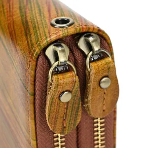 Primer plano detalle billetera hombre cuero genuino doble cremallera acabado estilo vintage.