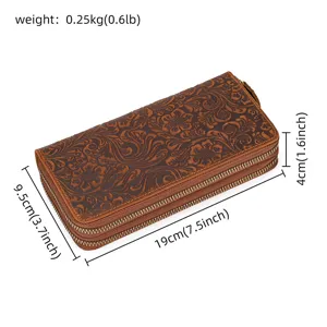 Vista detallada de cartera larga de cuero repujado vintage con cremallera y diseño floral.