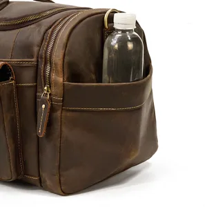 Primo piano della tasca laterale e della cerniera in metallo di questa borsa da viaggio in pelle.