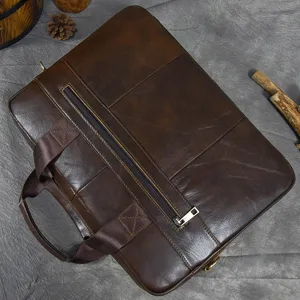 Close-up view of a brown leather business laptop bag, highlighting texture and metal zipper closure.
