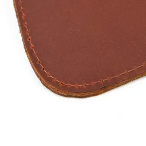 Gros plan de la bordure d'un portefeuille en cuir marron avec une texture de couture fine.