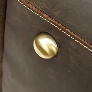 Dettaglio di borsa da viaggio vintage in pelle crazy horse con rivesto metallico e cucitura.