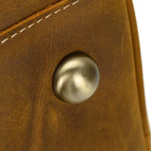 Detail du sac de voyage en cuir vintage montrant le clou de fond metallique et coutures