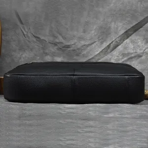 Detail view of the black men's genuine leather business briefcase, showcasing durable cowhide material.
