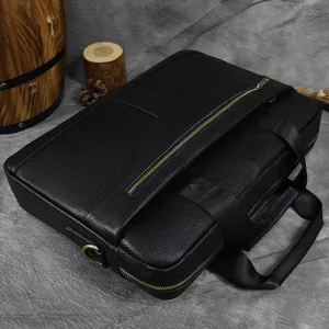 Black leather business briefcase closeup featuring durable top handles, metal zippers and ring.
