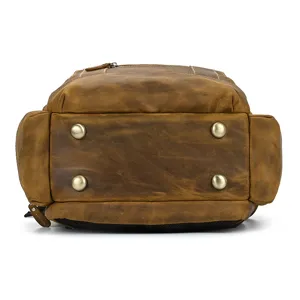 Close up view of genuine leather backpack bottom with metal feet and fine stitching details.
