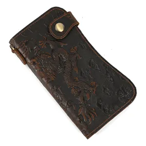 Gros plan détaillé d'un long portefeuille en cuir crazy horse véritable avec motif de dragon.