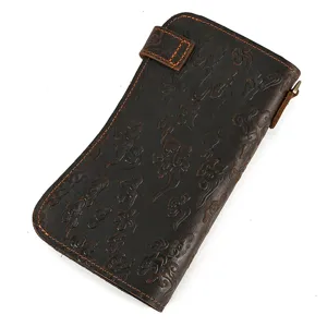 Détail de la texture en cuir véritable vintage avec motif dragon gaufré et surpiqûres.