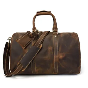 Gros plan sur le sac de voyage en cuir vintage marron, montrant texture et belles pièces métalliques.