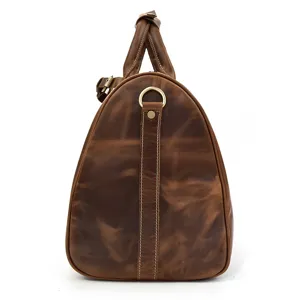 Détail latéral du sac de voyage en cuir vintage avec coutures et quincaillerie en métal.
