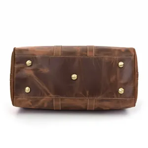 Détail du fond de sac de voyage en cuir de cheval fou vintage, cuir de vachette, pieds en laiton.