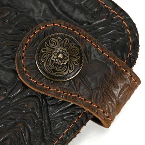 Gros plan détaillé d'un portefeuille en cuir avec motif de dragon gaufré et bouton pression.
