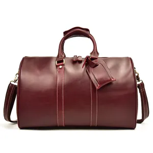 Vue détaillée d'un sac de voyage vintage en cuir véritable bordeaux avec texture de vachette.