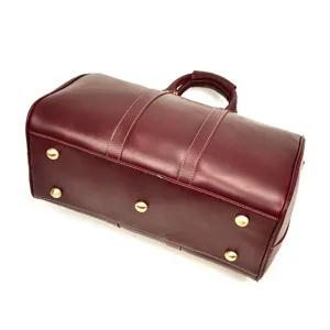Gros plan sur les détails du sac de voyage en cuir rétro avec clous en métal et coutures.
