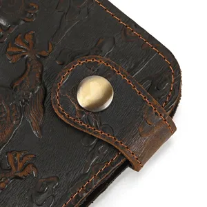 Vintage genuine leather wallet detail showing embossed pattern and bronze snap button.