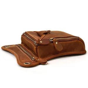 Close-up detail view of vintage brown cowhide leather drop leg bag with multiple metal zips.