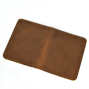 Close-up of vintage brown leather bifold card holder showing neat stitching and texture detail.