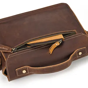 Close-up view of vintage leather bag zipper, handle and stitching detail texture.