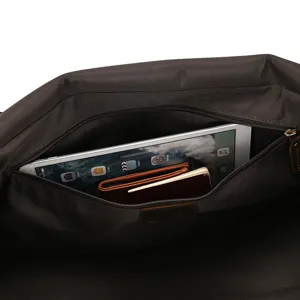 Vista detallada del interior de la bolsa de viaje de cuero marrón con gran bolsillo zip.