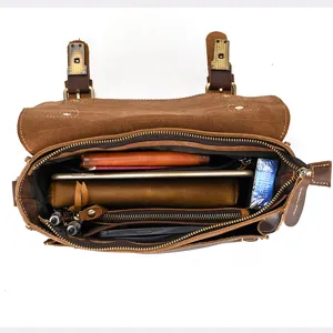 Vintage brown leather messenger bag interior detail showing spacious multi-pocket storage capacity.